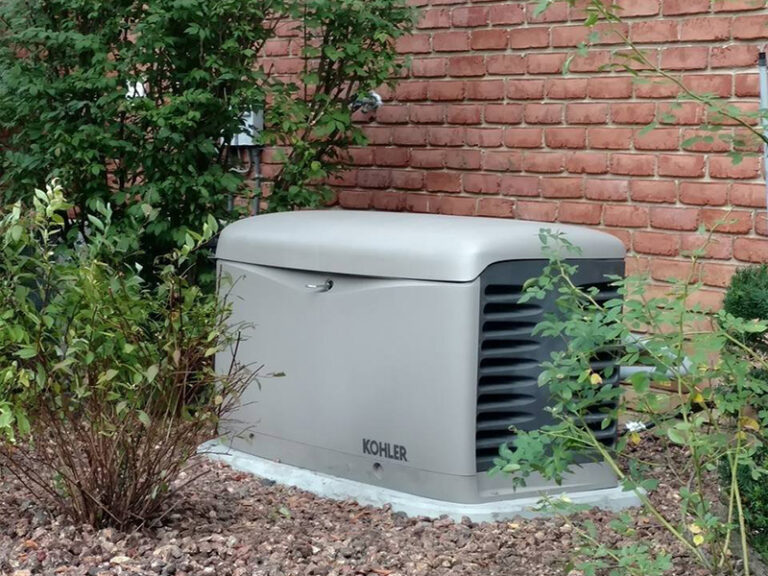 An installed whole-home generator next to a brick house