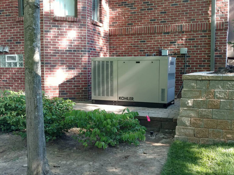 An installed whole-home generator next to a brick house